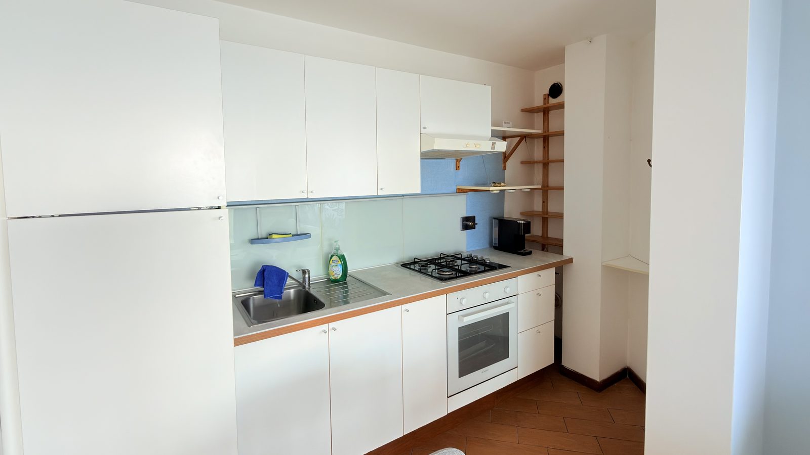 La cucina dell'Attico, con forno, fornelli e macchina del caffè